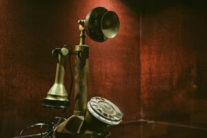 Antique brass candlestick telephone on a dark background