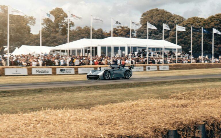 Race car speeds past spectators at an outdoor event