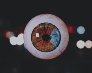a close up of an eyeball with blurry lights in the background